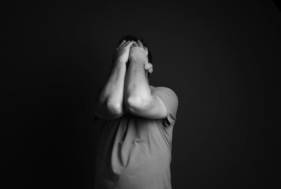 man covering his face with his hands